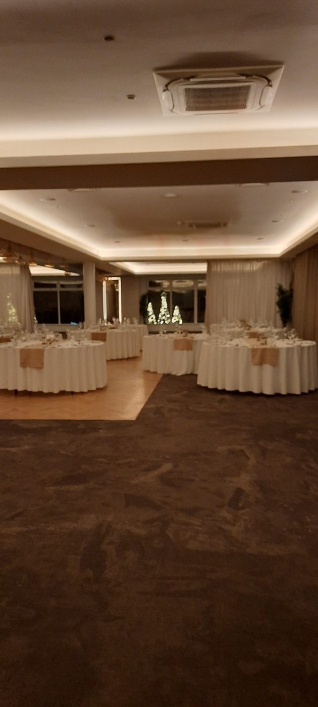 A function room with recessed ceiling lights and tables laid out